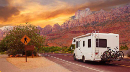 A RV drives into the sunset.